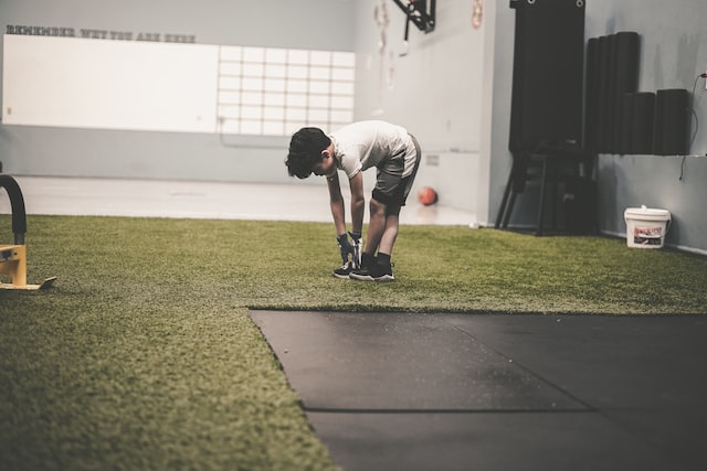 kid reaching his toes in a gymnasium