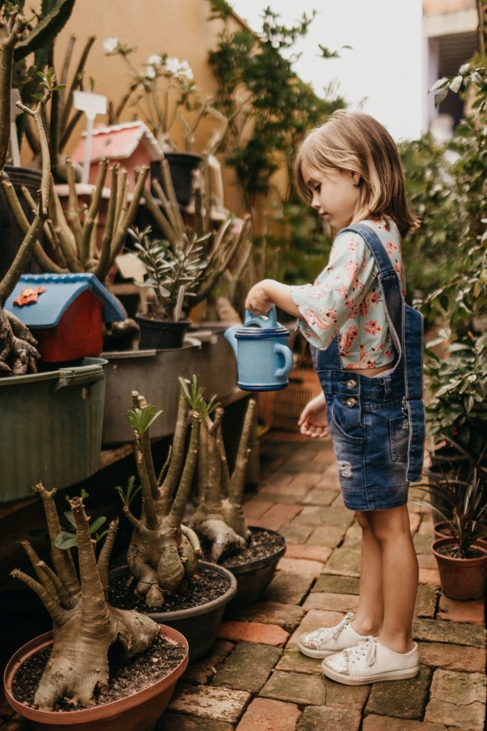 kid watering plants